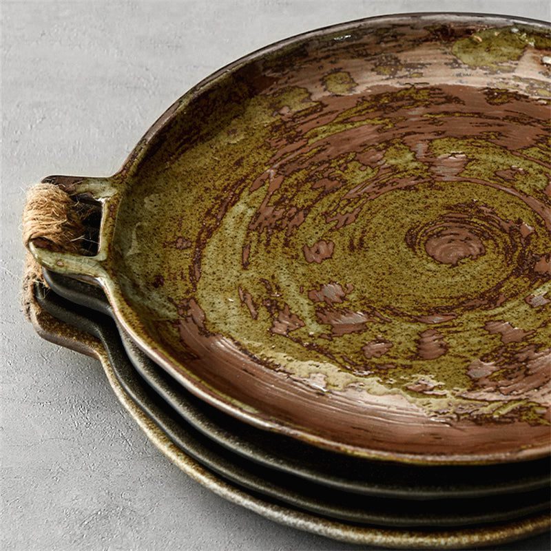 Assiettes créatives Hiroya brun et vert empilées, détail de l'anse et du motif