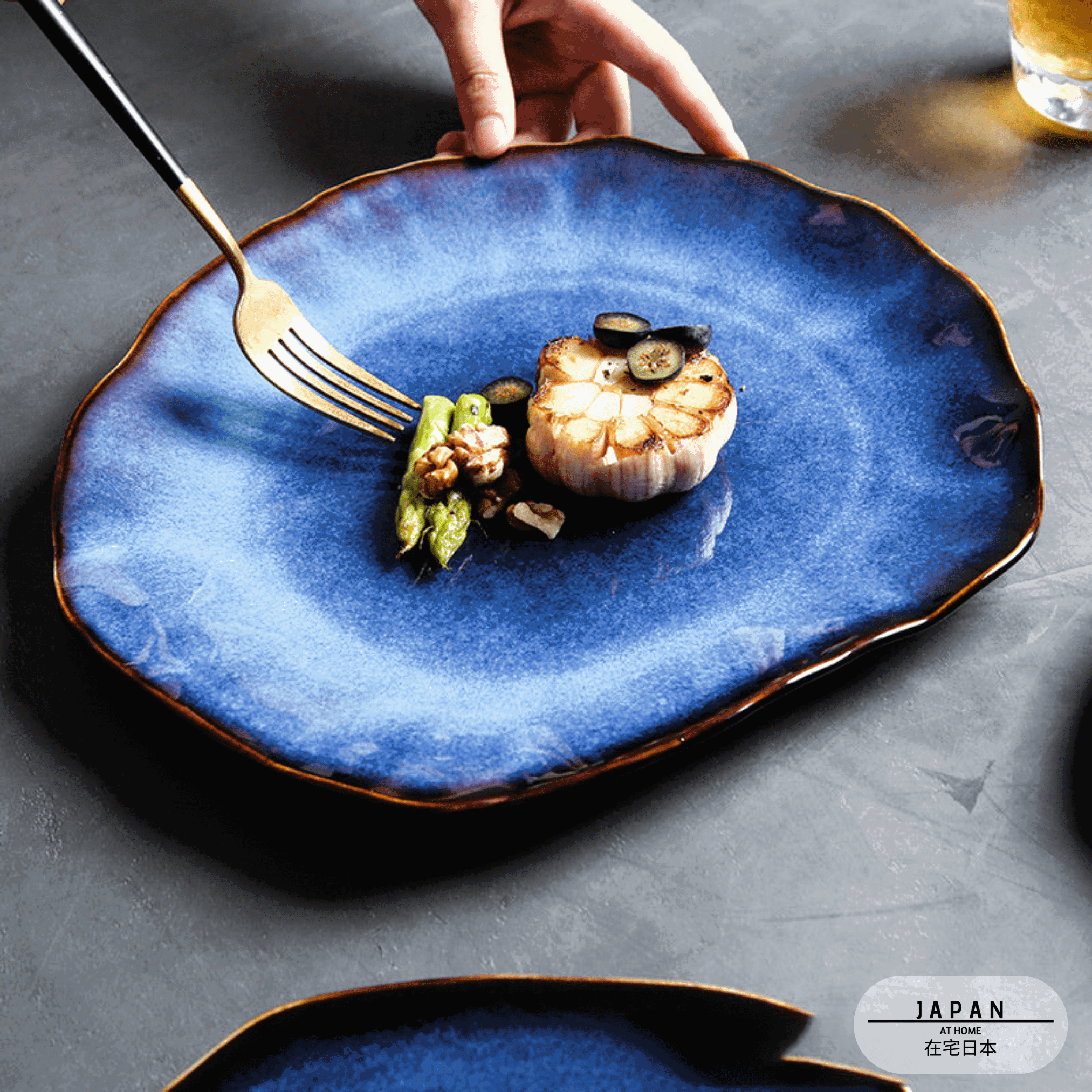 Assiette japonaise Hoshizora bleue garnie d'asperges et d'ail rôti, fourchette en main