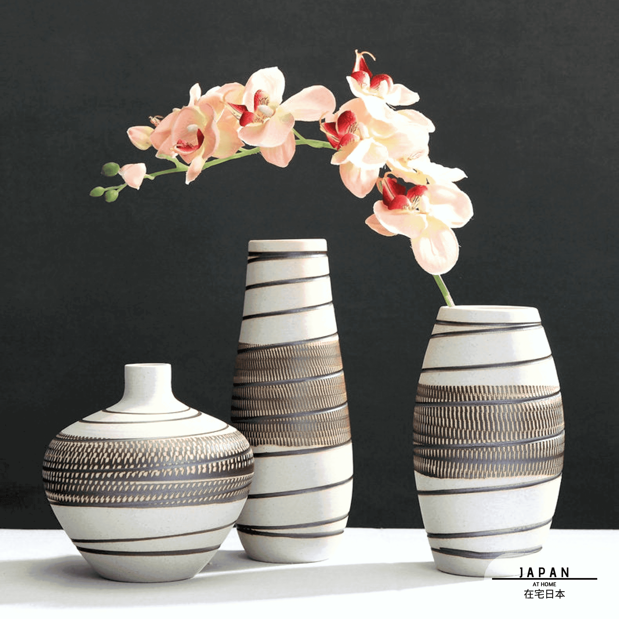 Trois vases en grès Kaze beige et marron avec une branche d'orchidée
