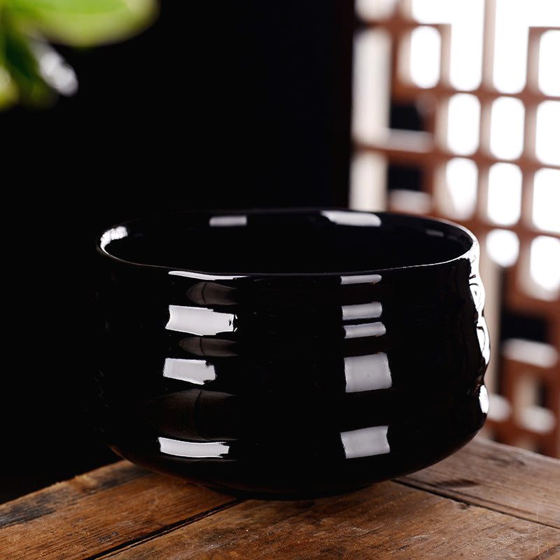 Tasse Kanda noire brillante, de face sur une table en bois