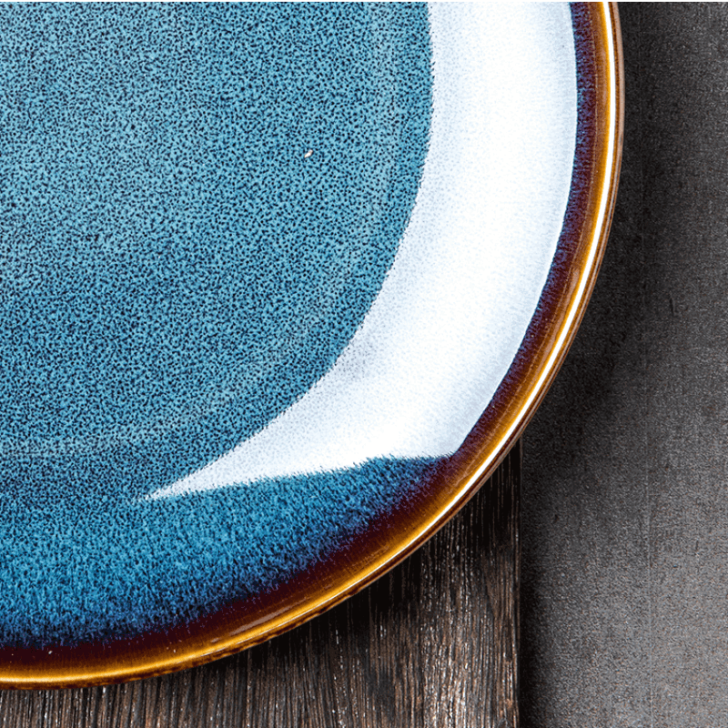 Détail du bord brun et du fond bleu moucheté de l'assiette japonaise Tatsuzo