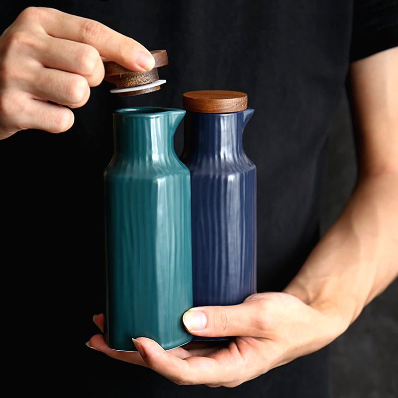 Bouteilles Kanpaï verte et bleue tenues en main, bouchon soulevé