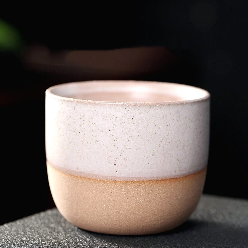 Tasse Niji en grès rose pastel, de face sur fond sombre