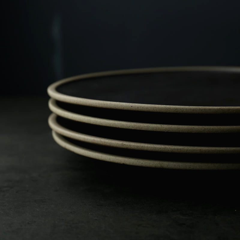 Pile de quatre assiettes Inoue noires vues de profil