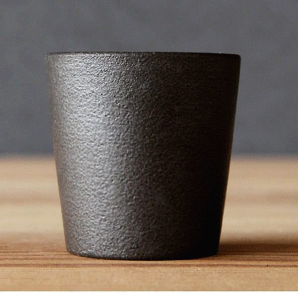 Petite tasse Isayama noire texturée posée sur une table