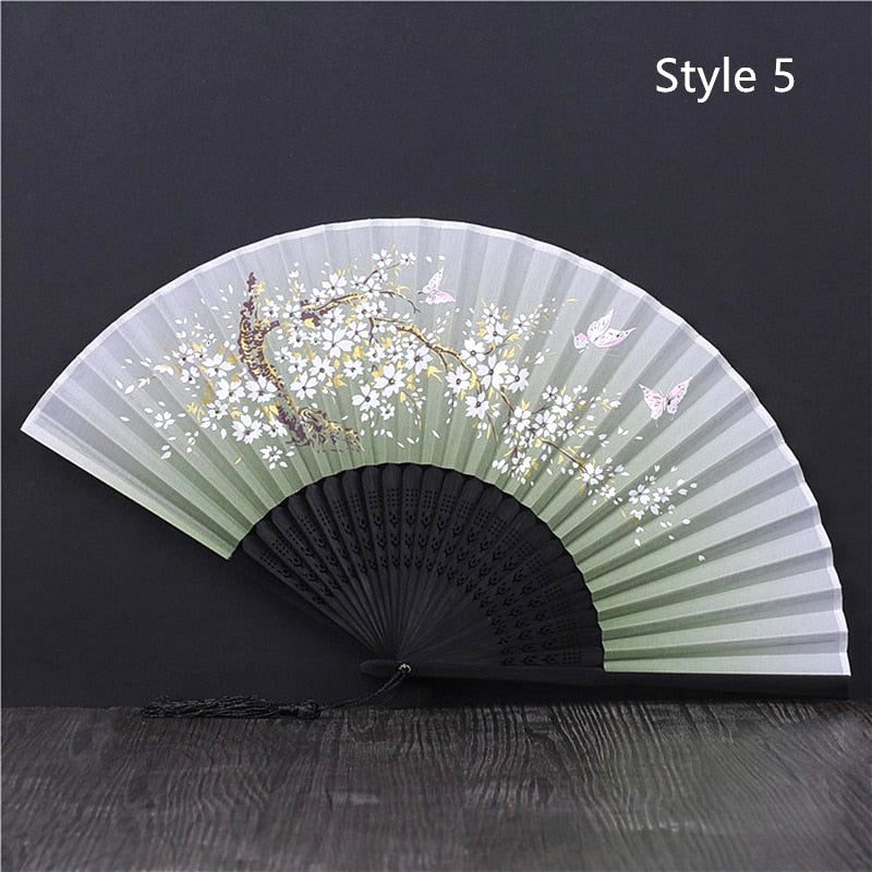 Éventail japonais en satin vert pâle à monture noire, fleurs blanches