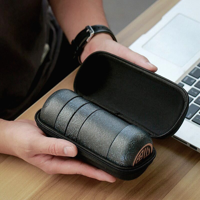 Service à thé portable Yoshii rangé dans son étui ouvert, tenu à deux mains