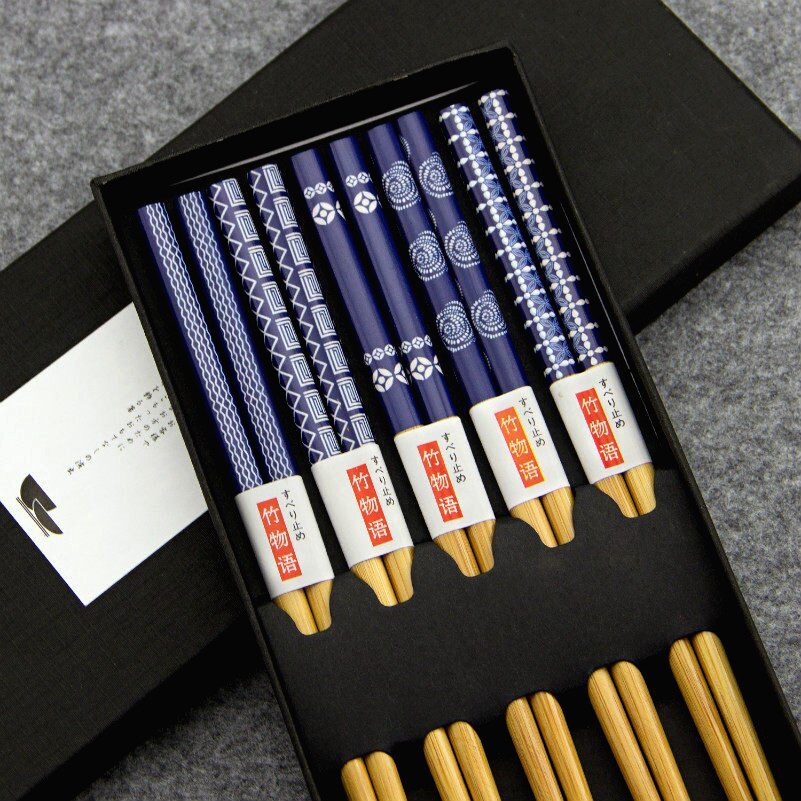 Coffret de baguettes en bois laqué bleu à motifs, ouvert sur fond gris
