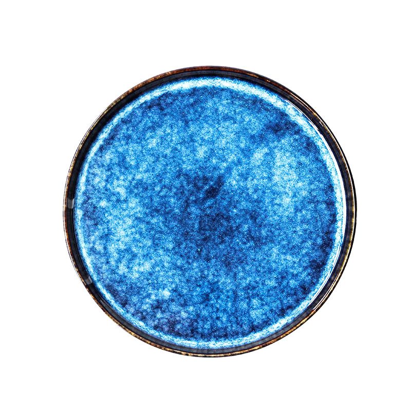 Assiette japonaise Aozora bleue mouchetée à bord sombre, vue de dessus sur fond blanc