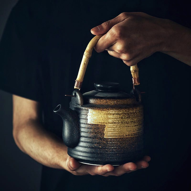 Théière japonaise Tīpotto ocre portée à deux mains, vue de profil