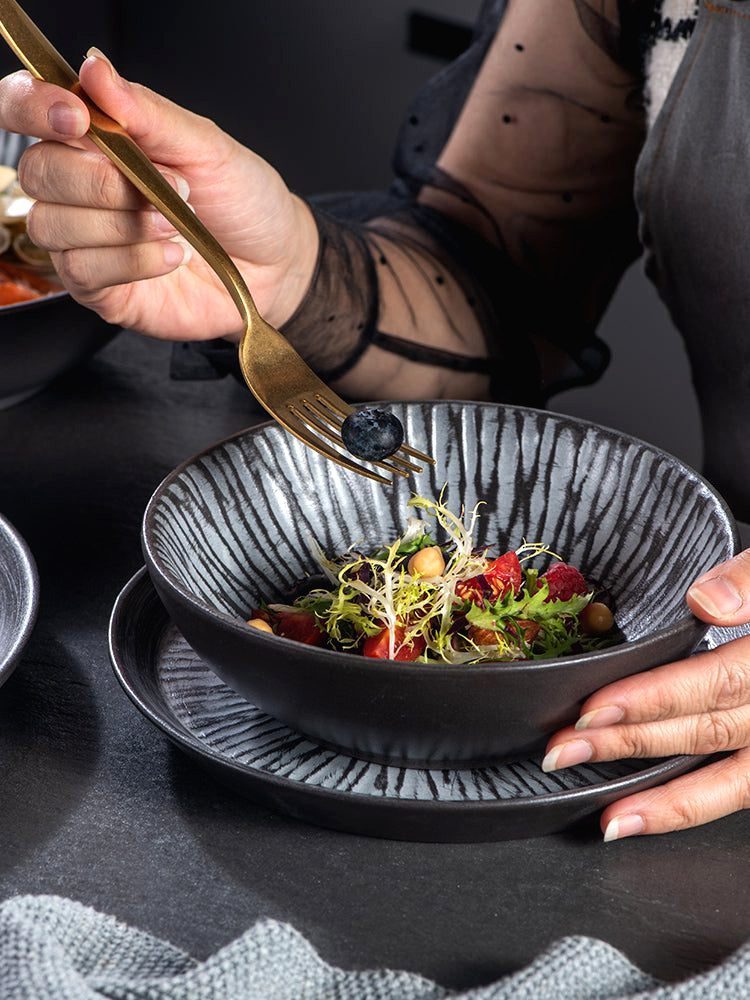 Bol japonais Tora garni de salade sur une assiette, fourchette en main