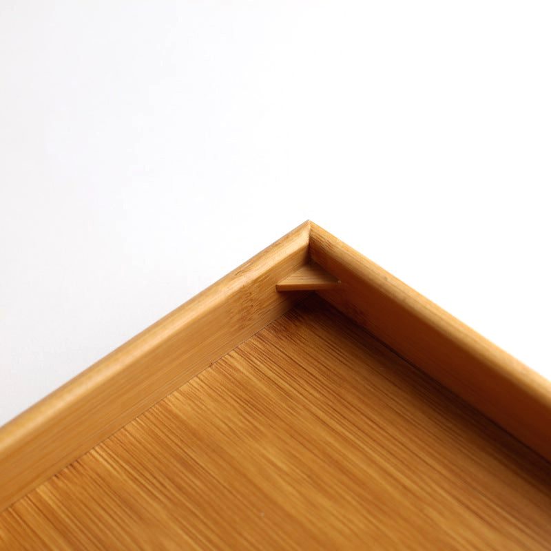 Détail d'un angle du plateau à thé en bambou et de son rebord
