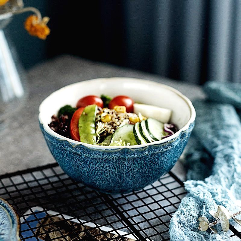 Bol Kizoku bleu rempli de salade posé sur une grille