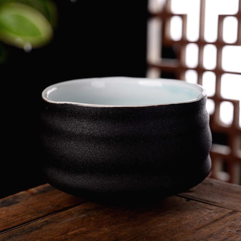 Tasse Kanda noire mate de face sur une table en bois