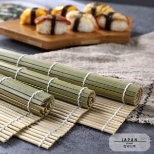 Nattes à sushi vertes en bambou roulées devant un plateau de sushis
