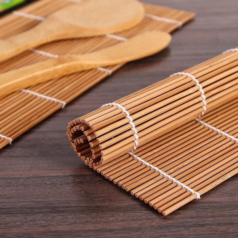 Natte à sushi en bambou roulée et spatules du kit en gros plan
