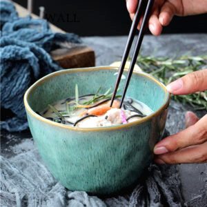Bol japonais Hōseki vert malachite rempli de soupe, baguettes en main
