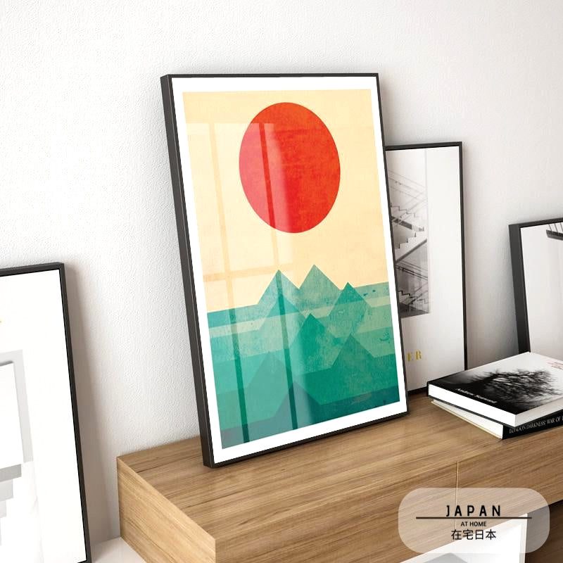 Affiche Soleil sur la montagne posée sur un meuble à côté de livres