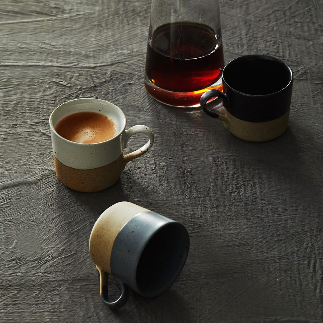 Trois tasses Tsuchi, dont une remplie de café, près d'une carafe