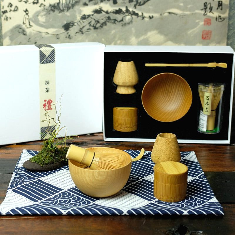 Kit matcha avec bol, fouet et boîte sur un tissu à vagues, coffret ouvert