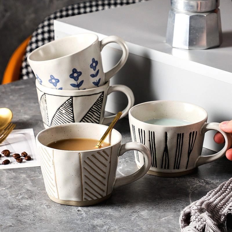 Quatre tasses Mieko, dont une remplie de café, sur une table