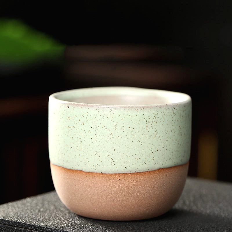 Tasse Niji en grès vert à base brute, de face