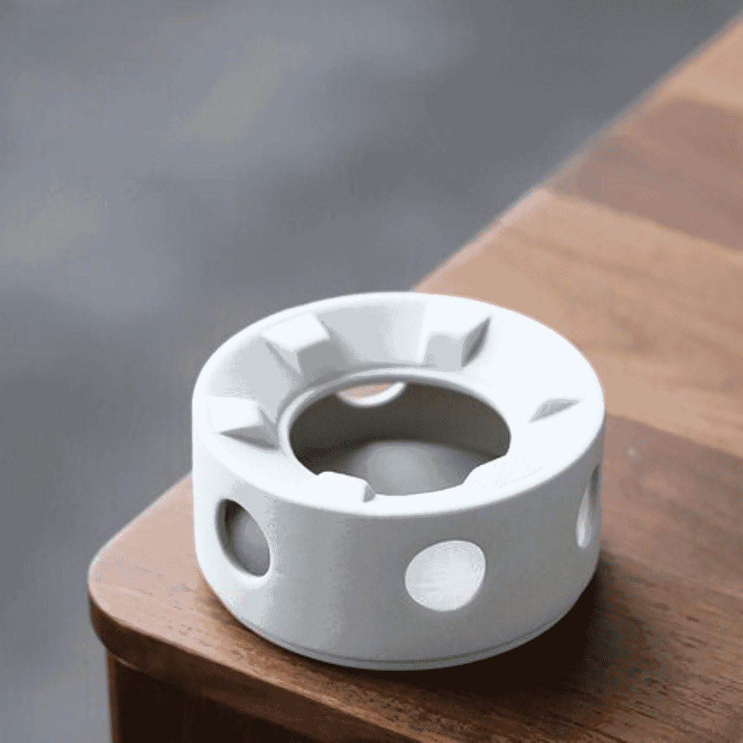 Réchaud blanc de la théière Montagne présenté seul sur une table