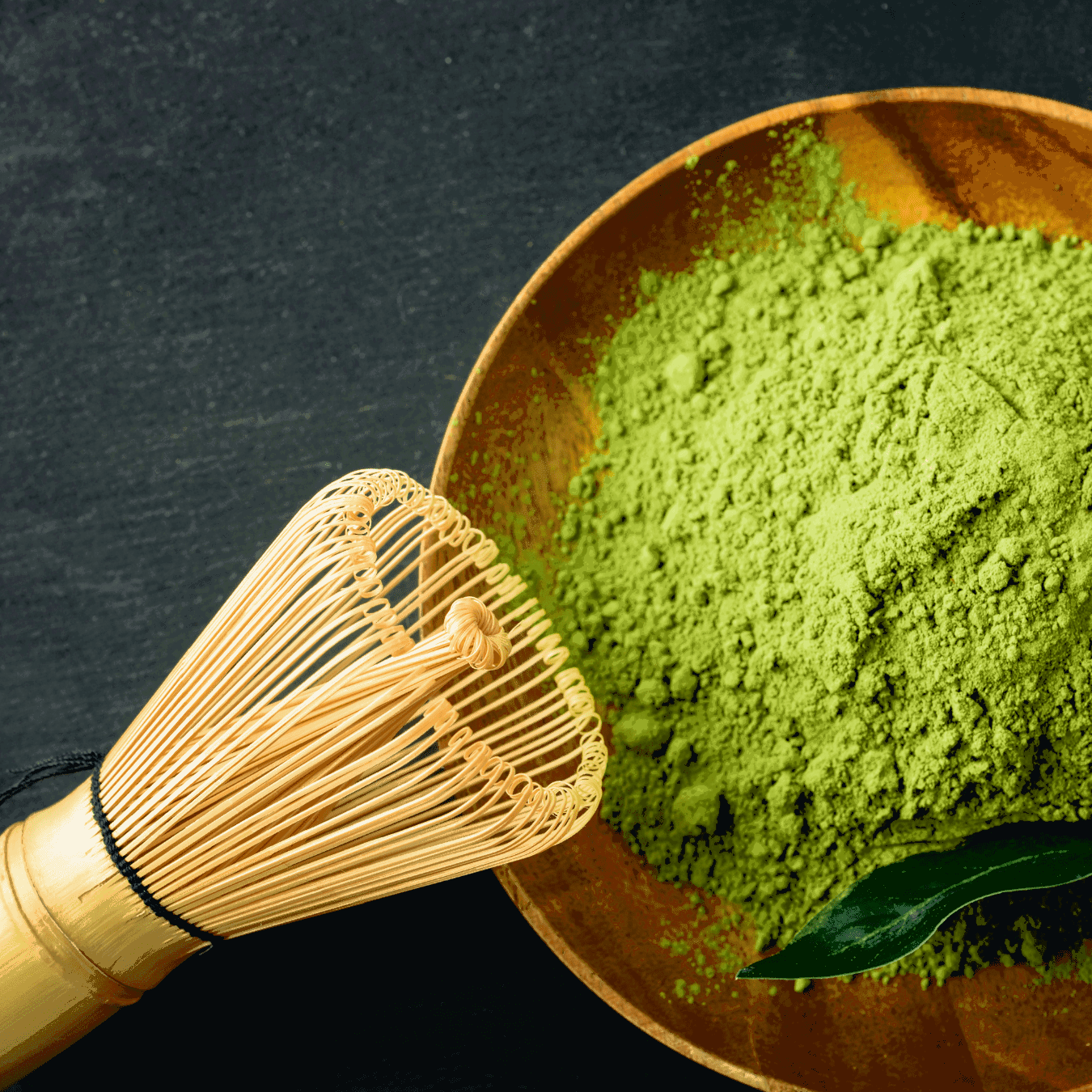 Matcha en poudre dans une coupe avec un fouet posé contre le bord