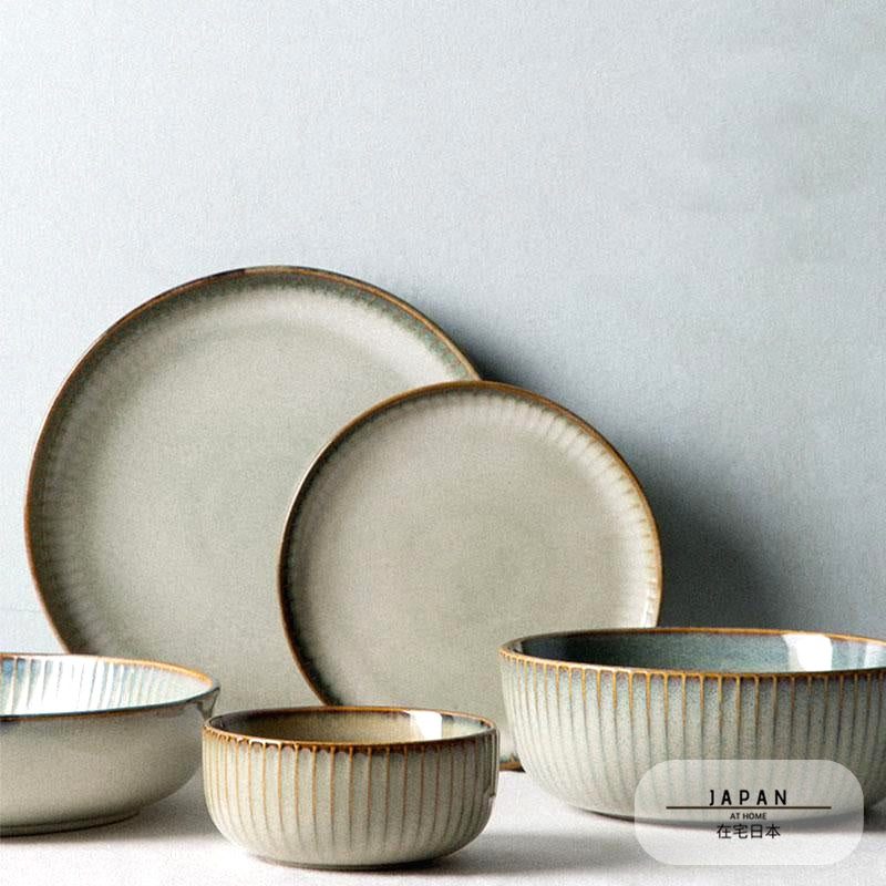 Collection Edano : assiettes et bols beiges réunis devant un mur clair