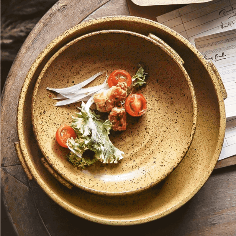 Assiettes japonaises Watsuji jaune moutarde empilées, garnies de tomates cerises et salade