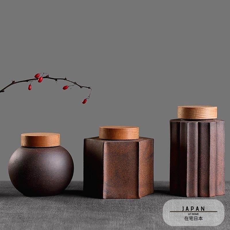 Trois pots à thé Sunada alignés sous une branche de baies rouges