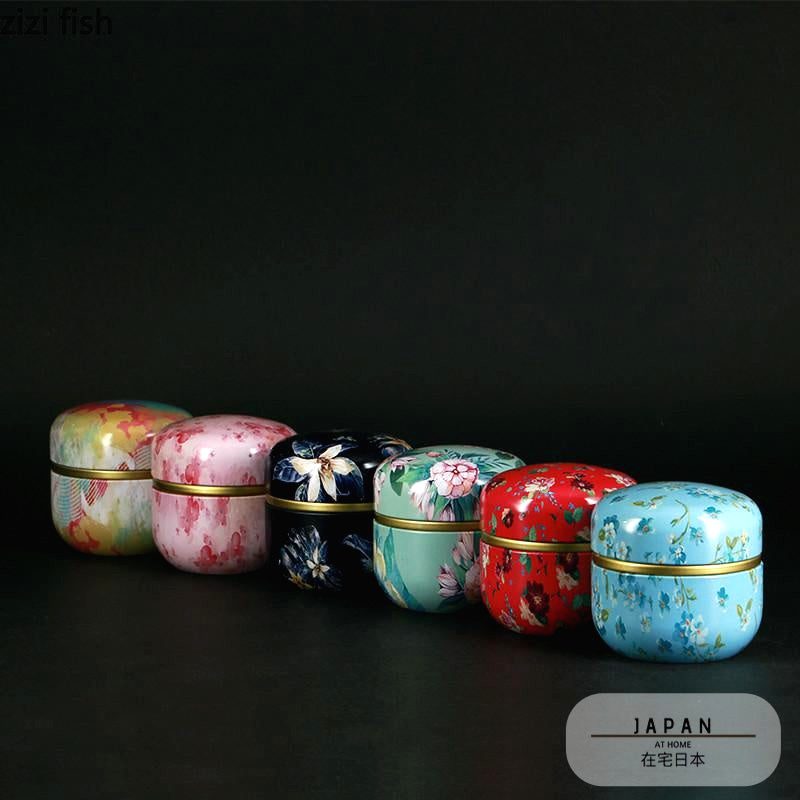 Six boîtes à thé Soma de couleurs différentes alignées sur fond noir