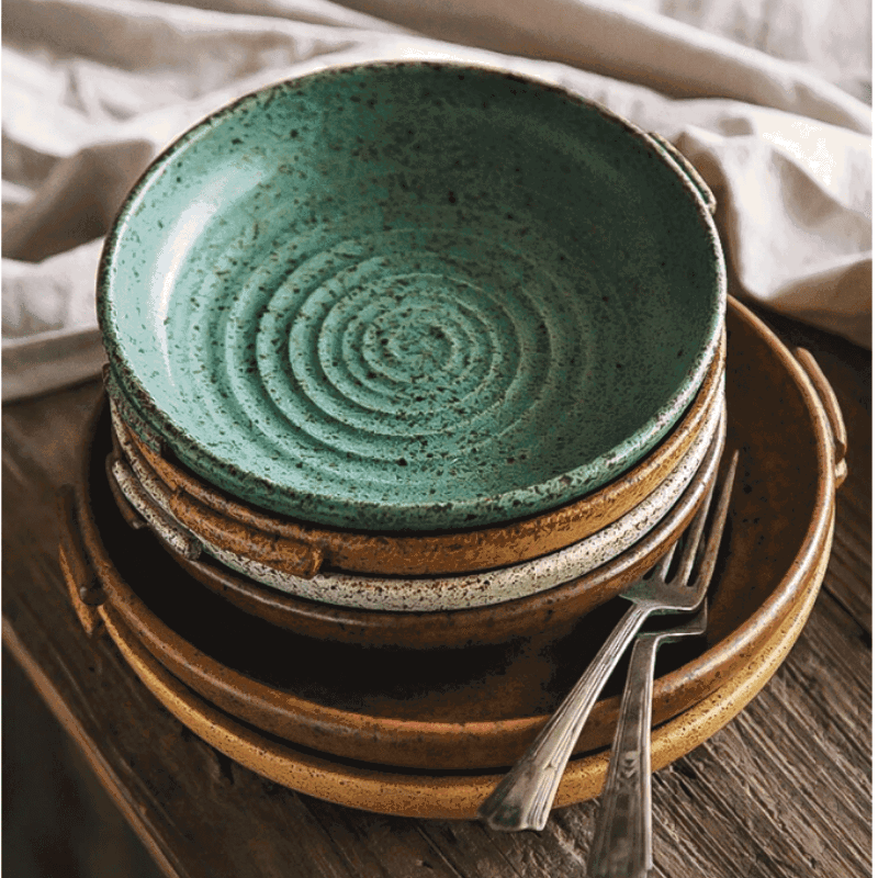 Assiettes japonaises Watsuji vert malachite, blanc cassé et rouge terre empilées avec fourchettes