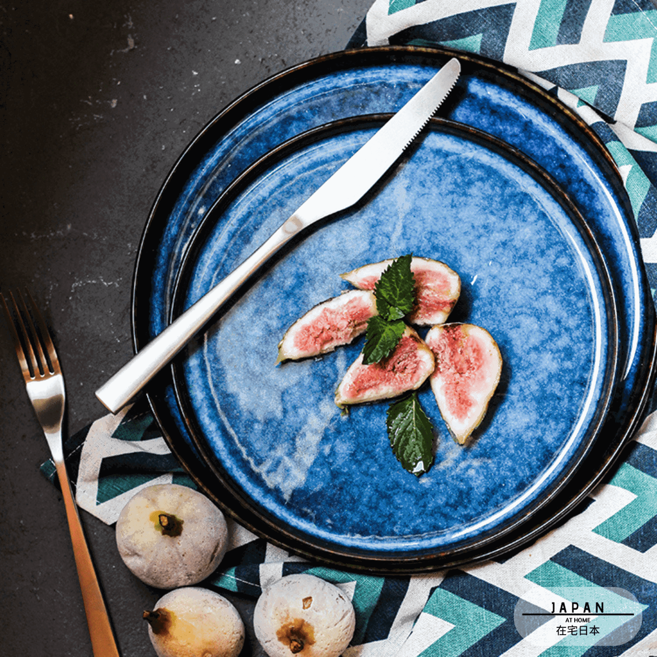 Deux assiettes japonaises Aozora bleues empilées avec figues, couteau et fourchette