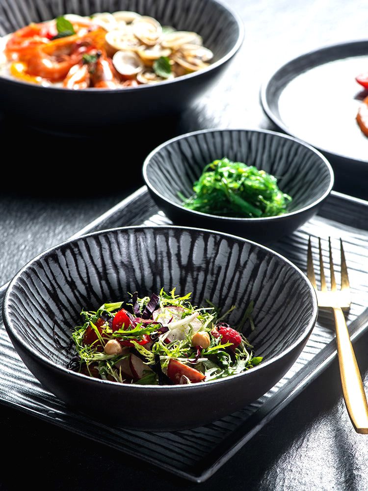 Bols japonais Tora garnis de salade et d'algues sur un plateau noir