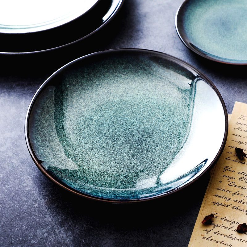 Assiette bleue en céramique Mihara vide, posée sur une table sombre