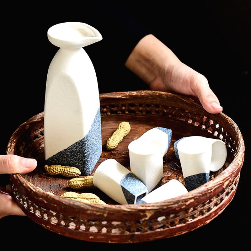 Carafe et tasses à saké Iwao présentées dans un panier tressé