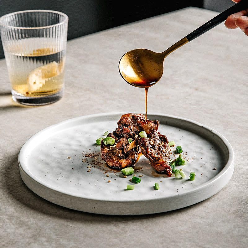 Assiette japonaise Tsuki blanche garnie de viande nappée de sauce versée à la cuillère