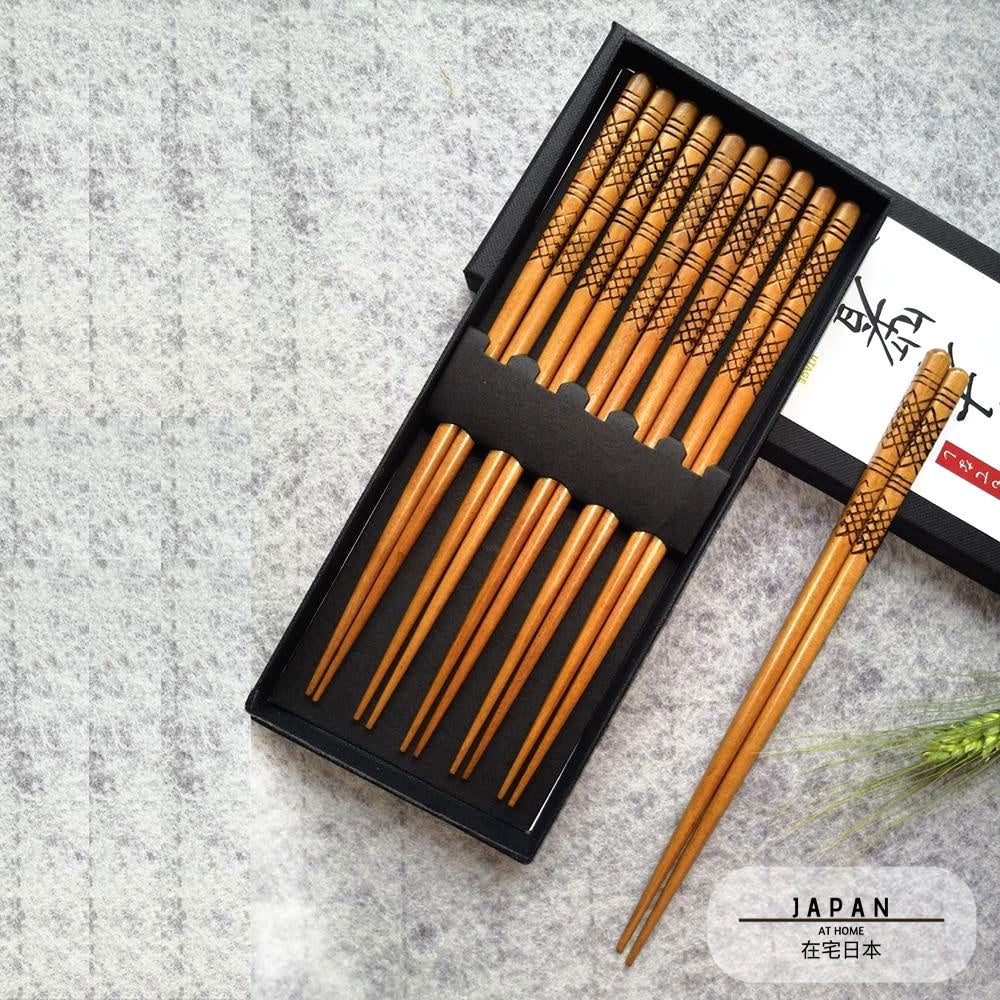 Coffret de baguettes japonaises gravées ouvert, une paire sortie de la boîte