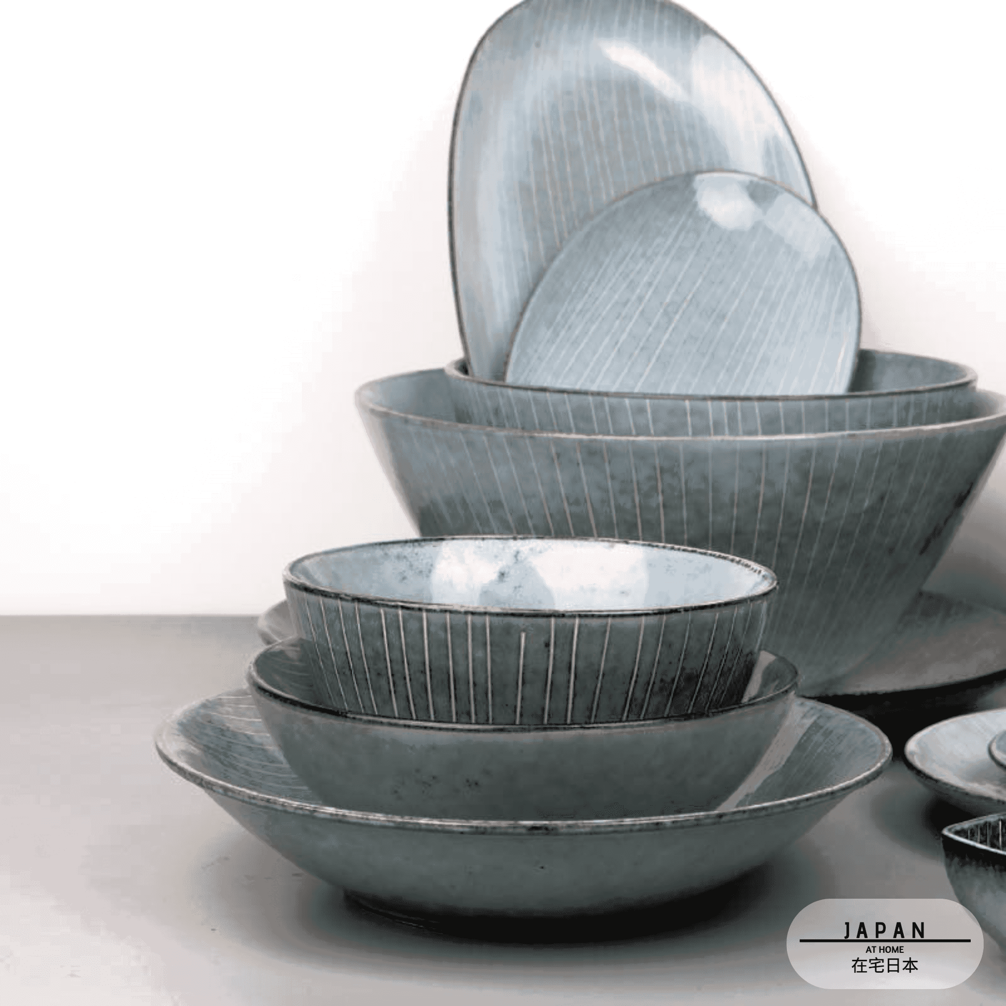 Bols et assiettes de vaisselle japonaise Sora empilés sur fond blanc