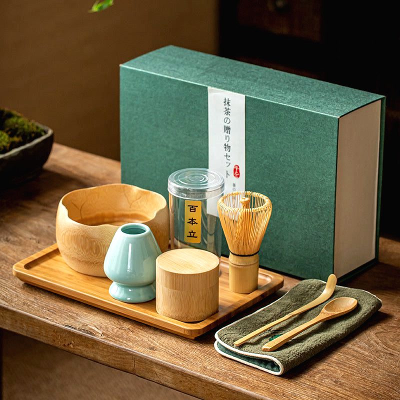 Coffret matcha avec bol beige, porte-fouet vert et cuillère devant sa boîte