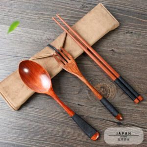 Cuillère, fourchette et baguettes en bambou posées sur leur pochette en tissu