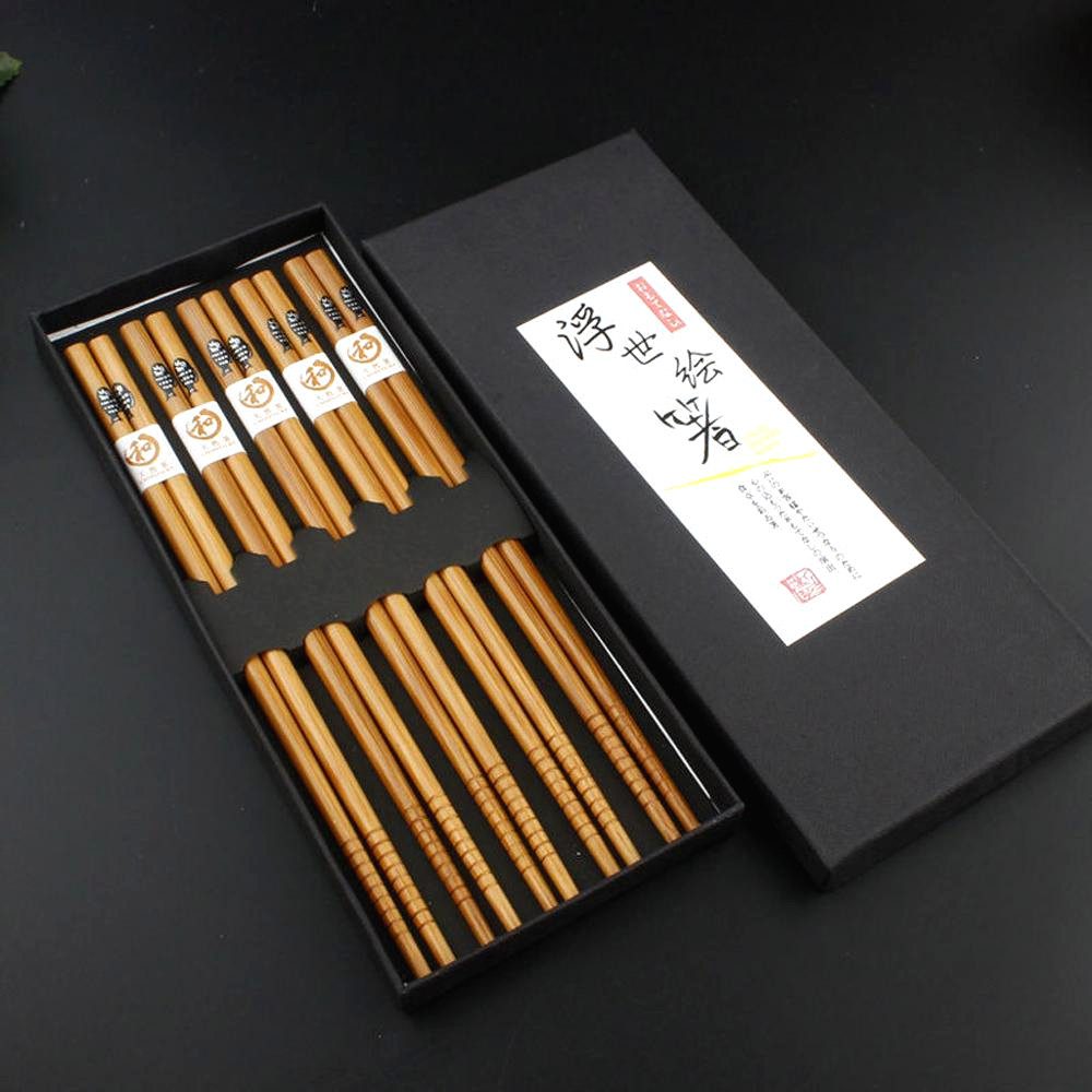 Coffret de baguettes japonaises motif poisson et son couvercle sur fond noir