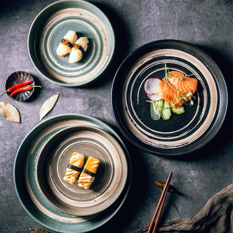 Trois assiettes japonaises Azami vues de dessus avec sushis, saumon et baguettes