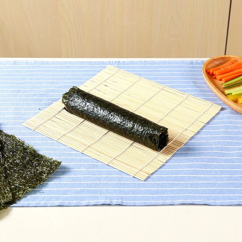 Natte à sushi en bambou avec un rouleau de maki et une feuille d'algue