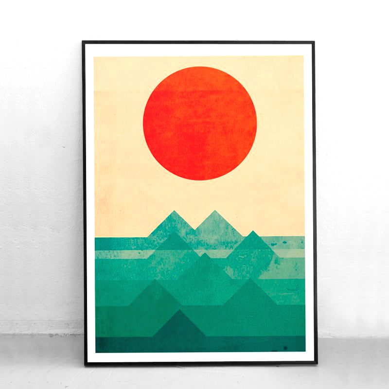 Affiche Soleil sur la montagne en cadre noir posée contre un mur blanc