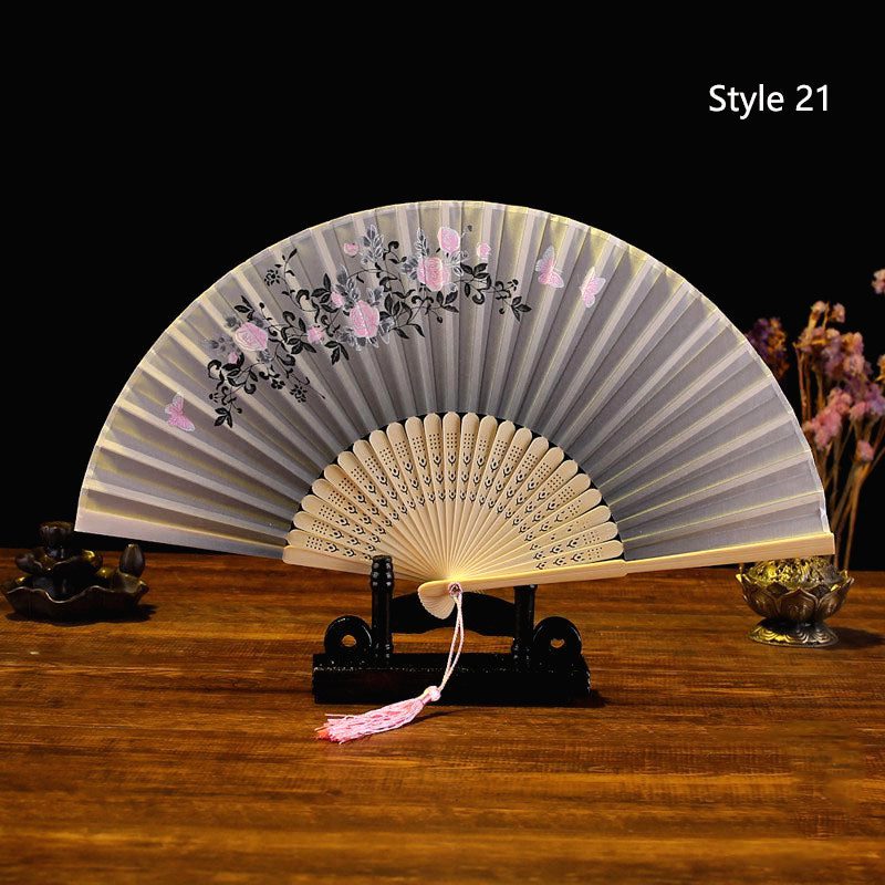 Éventail japonais en satin gris argenté, fleurs roses, posé sur un support