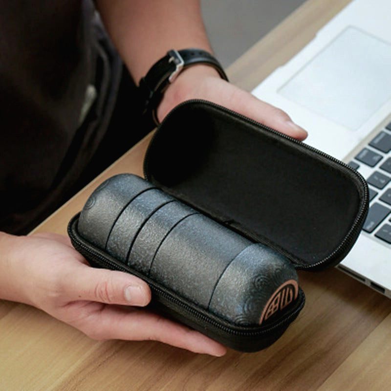 Étui ouvert du service à thé Yoshii devant un ordinateur portable