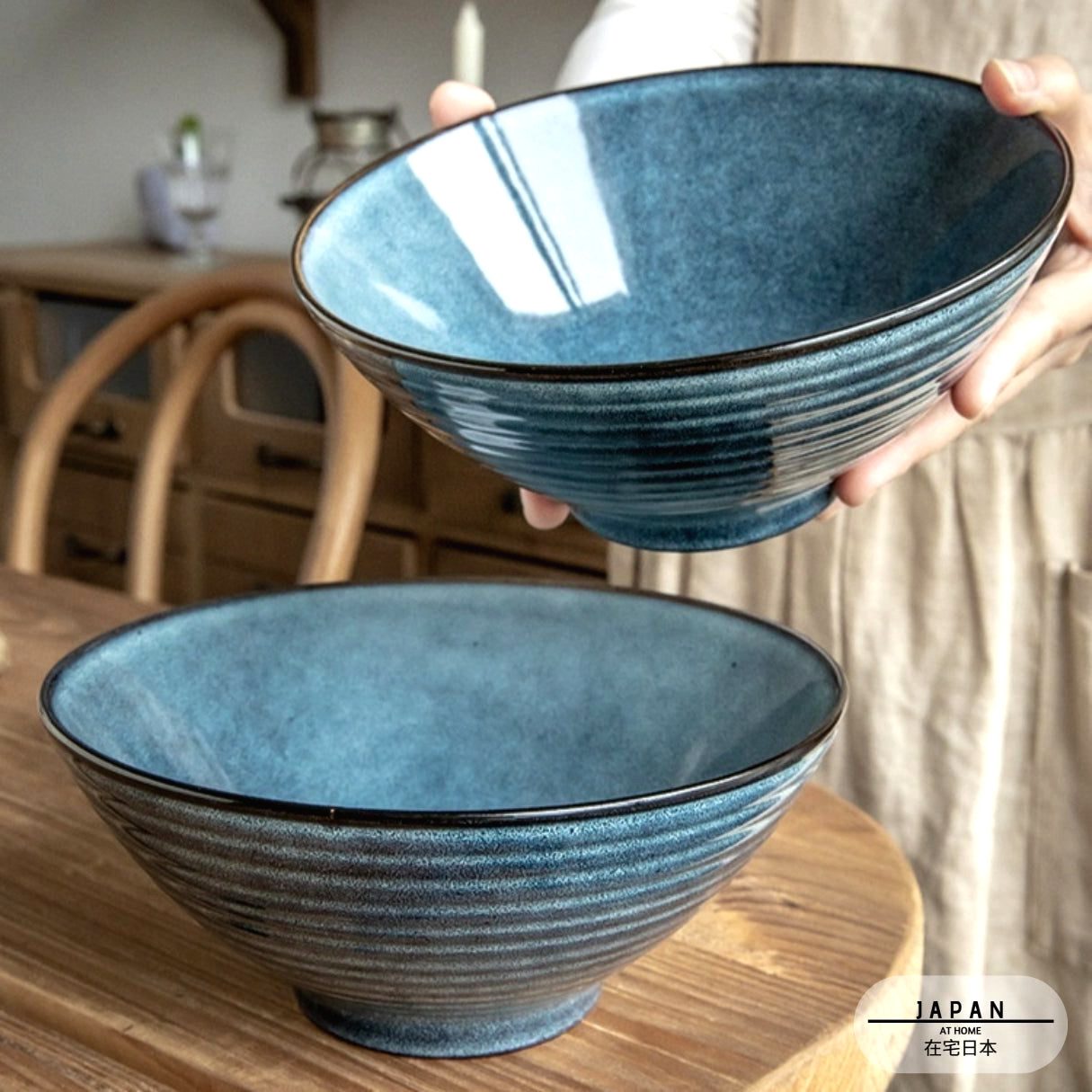 Bol à ramen Towada bleu tenu au-dessus d'un second bol sur une table