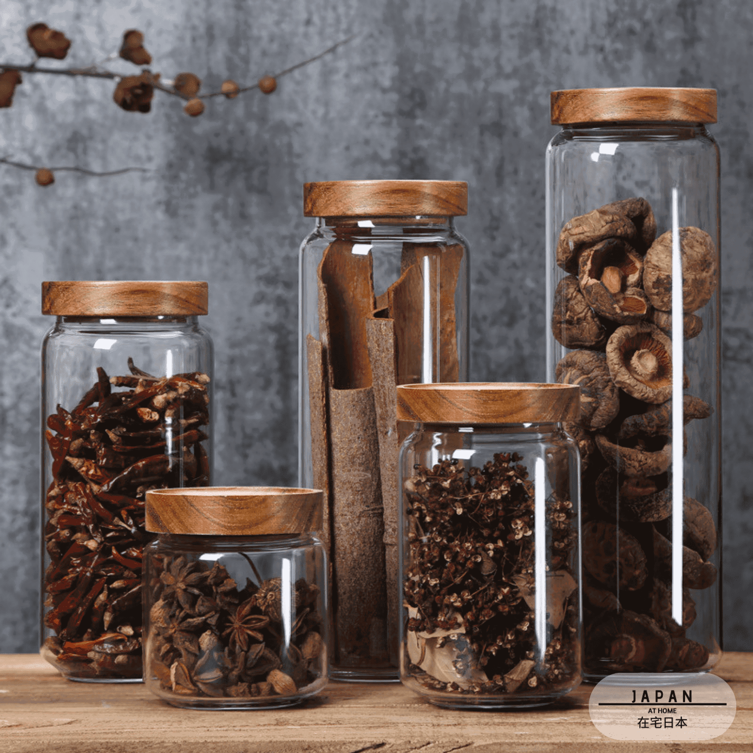Bocaux Akashia de plusieurs hauteurs remplis d'épices sur une table en bois